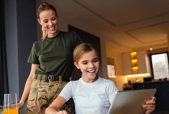 an image of a proud military mom and daughter happily using EarthLink internet service